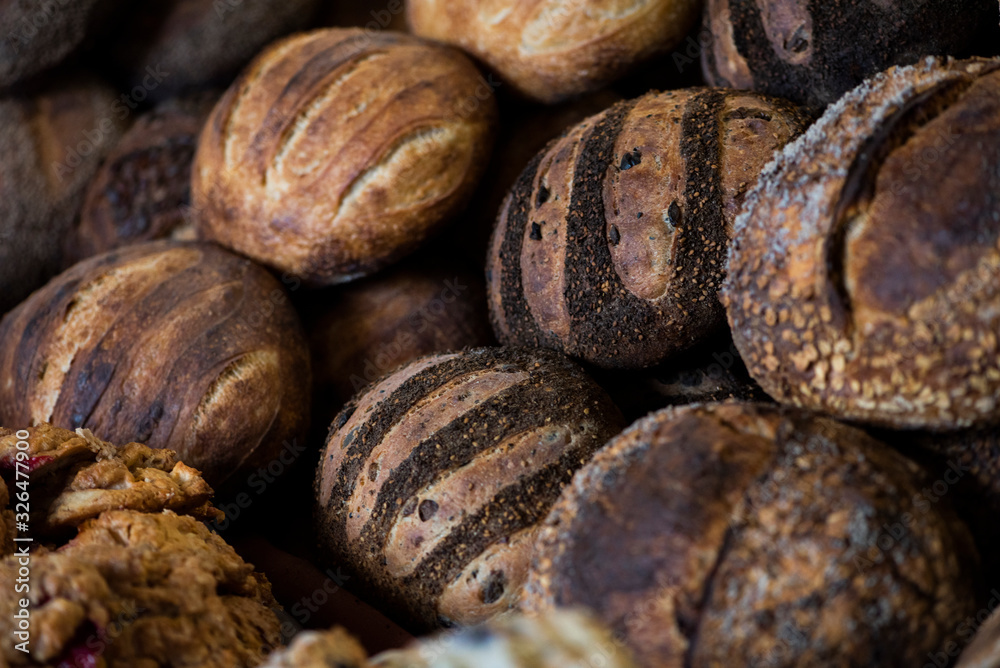 large assortment of freshly baked bread at local bakery, stacked loaves, artisan loaf of bread large assortment of freshly baked bread at local bakery, stacked loaves, artisan loaf of bread