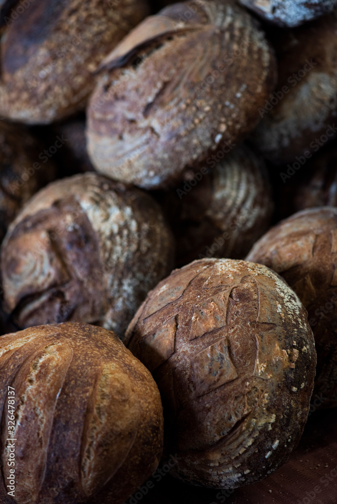 large assortment of freshly baked bread at local bakery, stacked loaves, artisan loaf of bread large assortment of freshly baked bread at local bakery, stacked loaves, artisan loaf of bread