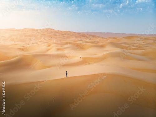 Couple among desert sand dunes aerial view