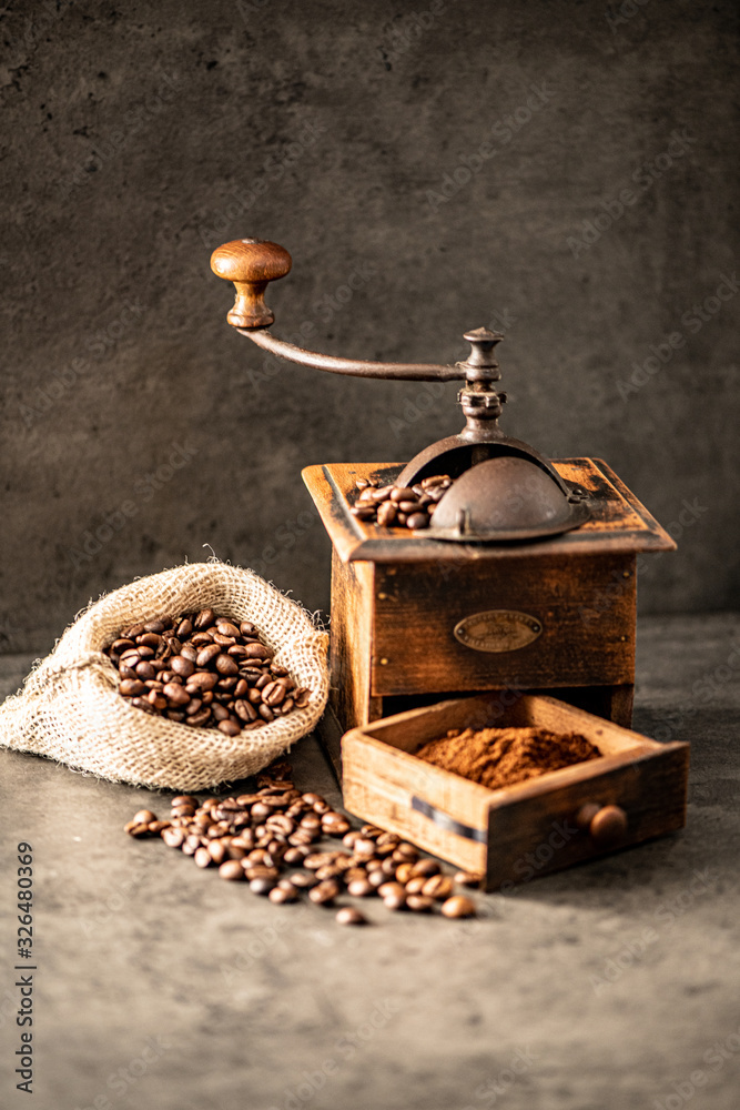 coffee grinder and beans on cement background