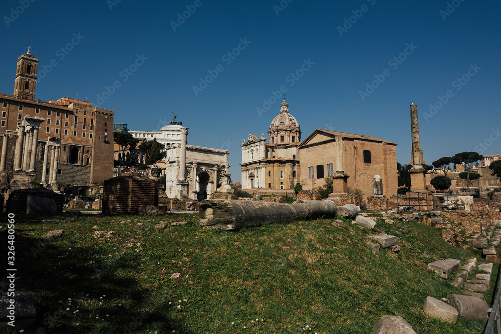 Daytime panoramic sunny photo of the ancient ruins of the Roman Forum. Scenic view on Foro Romano in Rome.