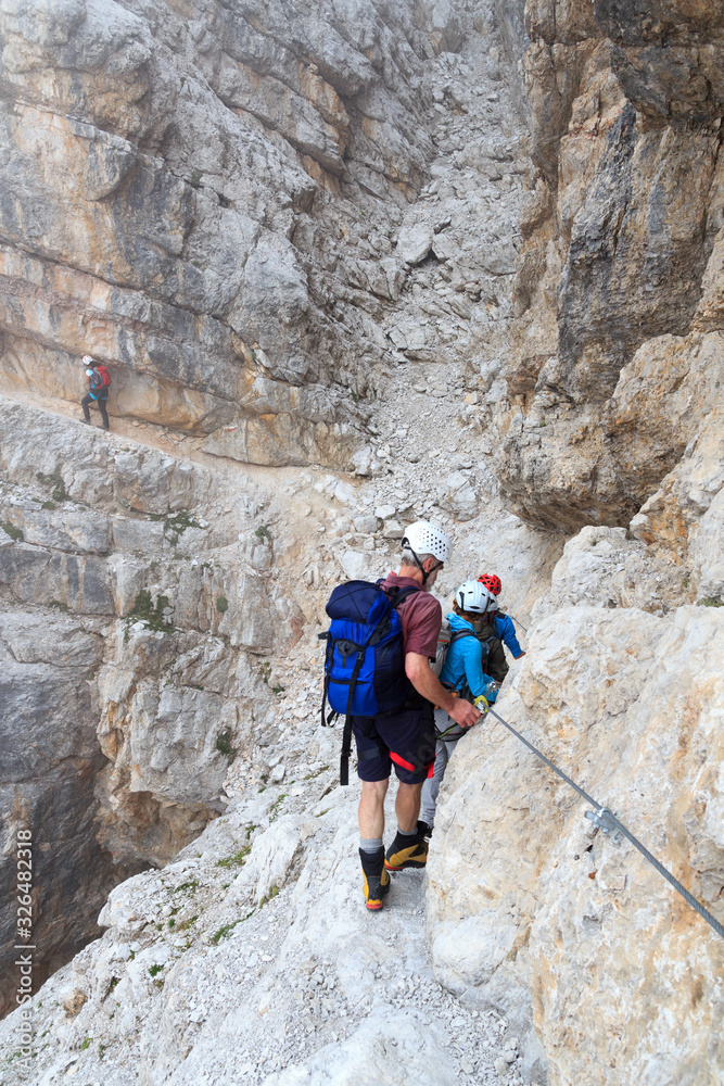 People climbing the Via Ferrata Sentiero Benini in Brenta Dolomites mountains, Italy