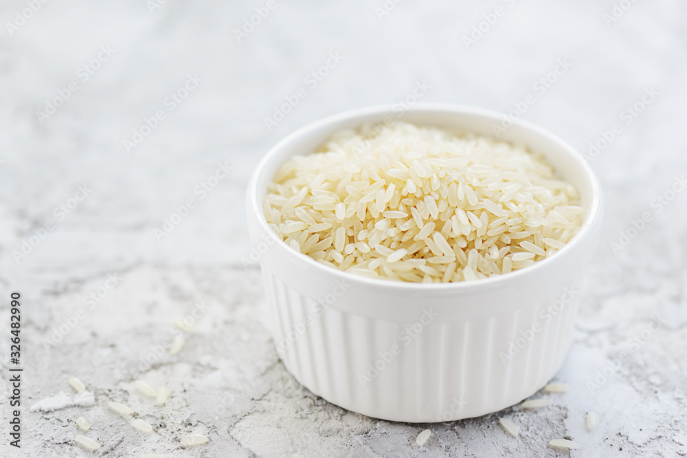 White rice in a bowl on a gray table. Gluten free, healthy diet concept. Horizontal orientation, copy space. White rice in a bowl on a gray table. Gluten free, healthy diet concept. Horizontal orientation, copy space.