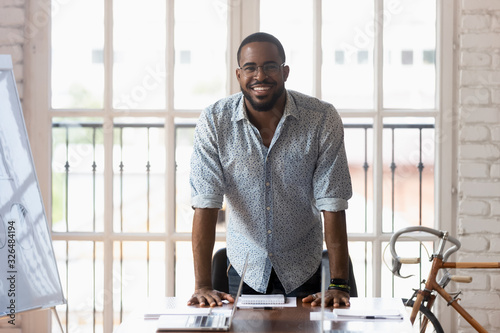African businessman posing looking at camera near table in boardroom