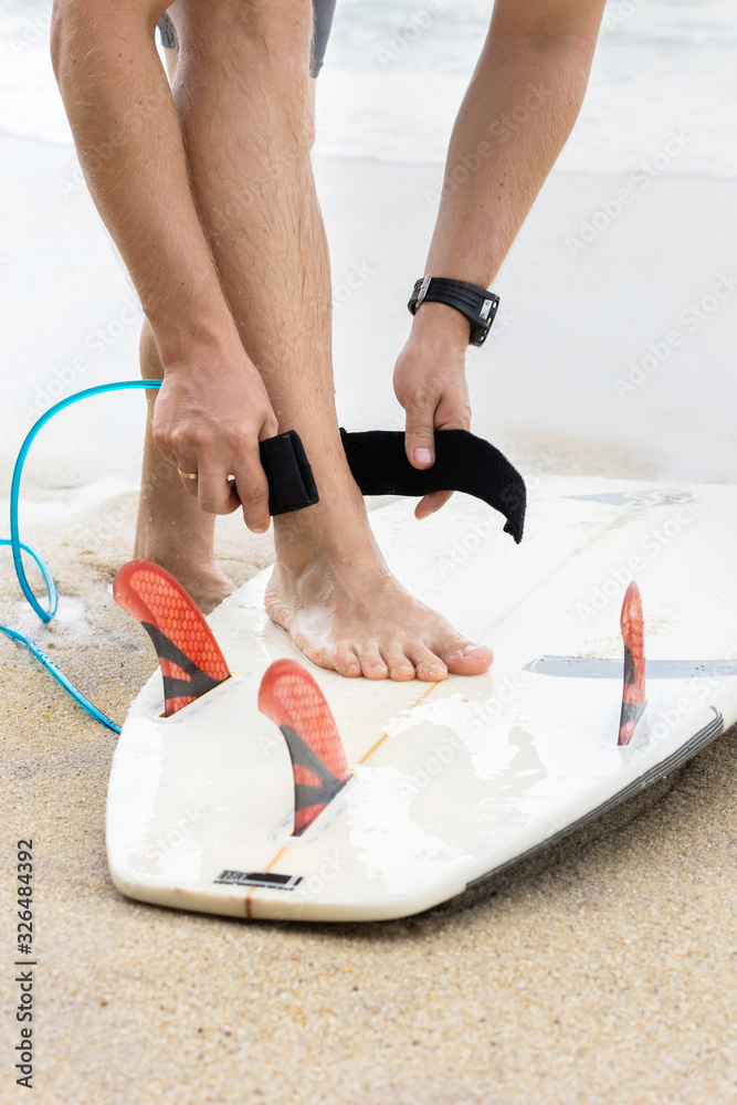 Surfing man leg leash on the beach. Surfing man leg leash on the beach.
