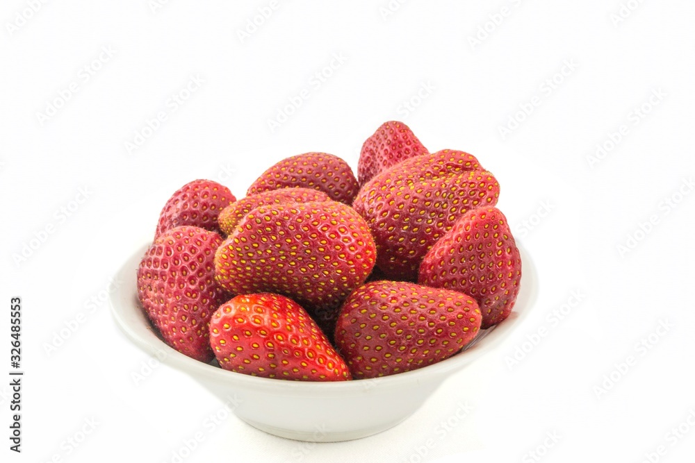 red strawberry berries in a plate on a white background