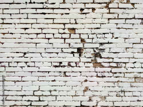 Painted brick wall of an architectural structure in light gray color. Fashionable texture for design.