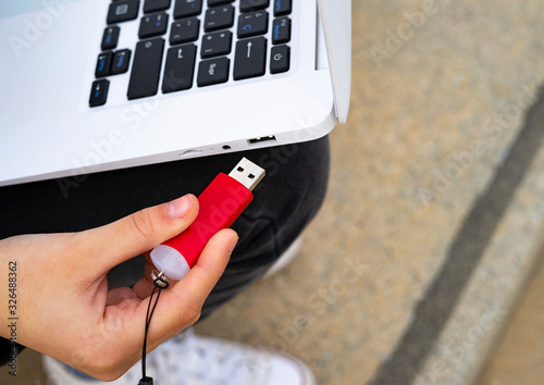 Hand connecting a Pendrive to the laptop.