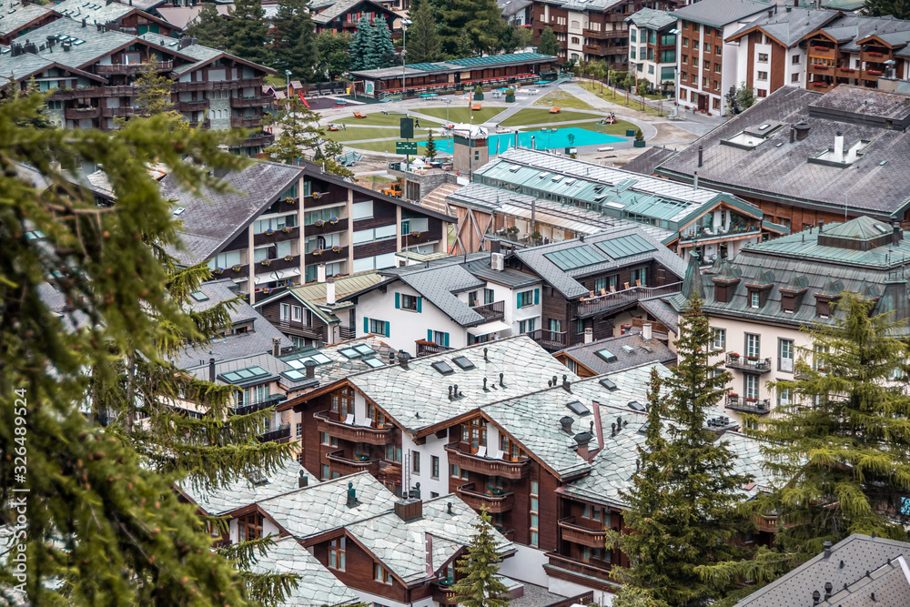 Fototapeta premium Wooden chalets and hotels in swiss village in Alps, Switzerland