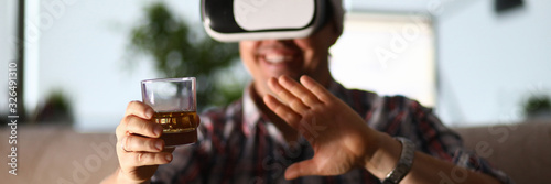Sticker Man sit at sofa hold glass in hand and using vr gogles
