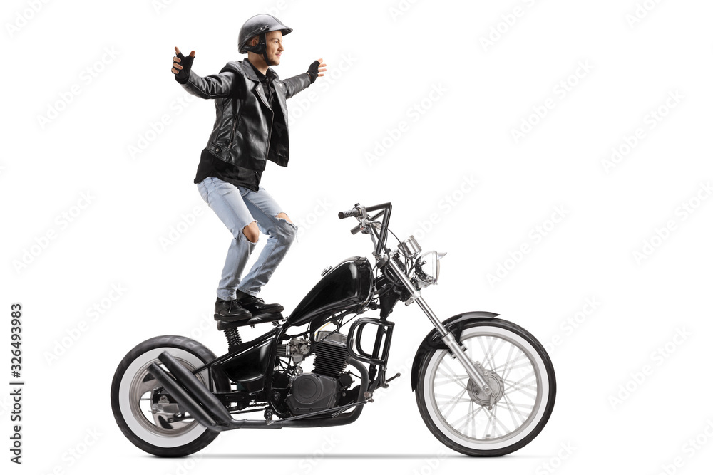Naklejka premium Daredevil riding a customized motorbike and standing on the seat