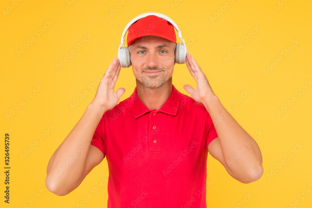 Best sounding headphones. Happy guy wear headphones yellow background. Handsome man listen to music in headphones. Using wireless headphones for audiophiles. Modern life. New technology Best sounding headphones. Happy guy wear headphones yellow background. Handsome man listen to music in headphones. Using wireless headphones for audiophiles. Modern life. New technology