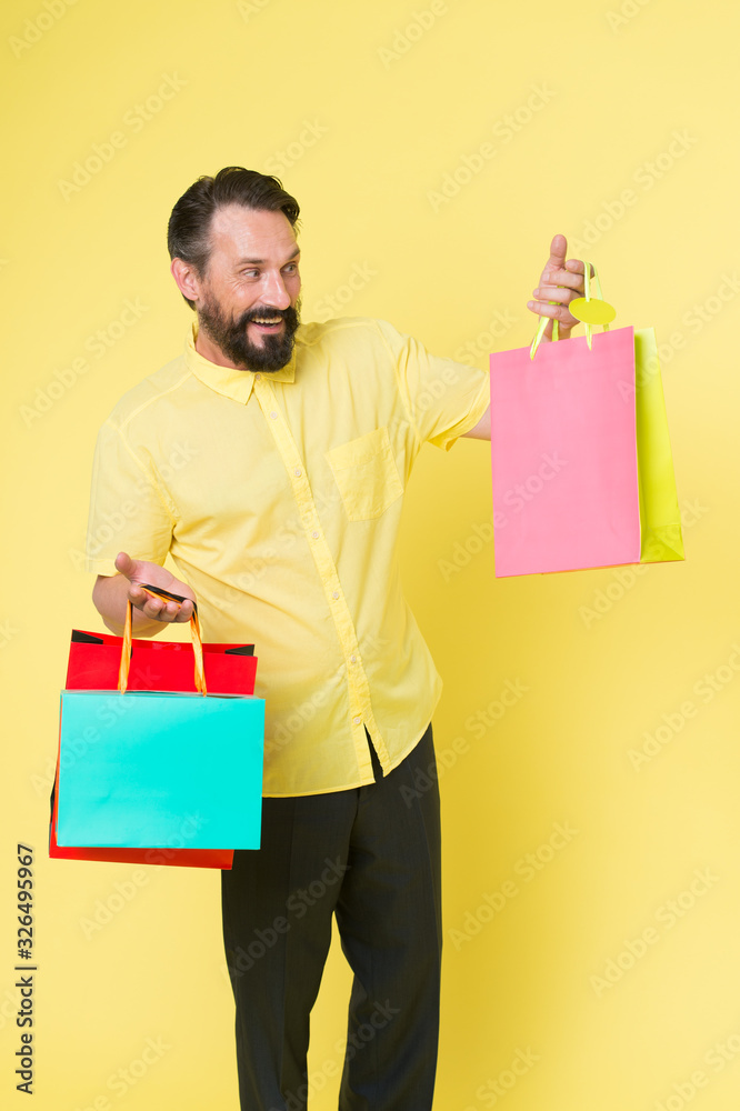Shop and enjoy. Shopping addict yellow background. Mature man hold shopping bags. Happy shopper with paperbags. Sale and shopping. Shopping as it should be, copy space Shop and enjoy. Shopping addict yellow background. Mature man hold shopping bags. Happy shopper with paperbags. Sale and shopping. Shopping as it should be, copy space
