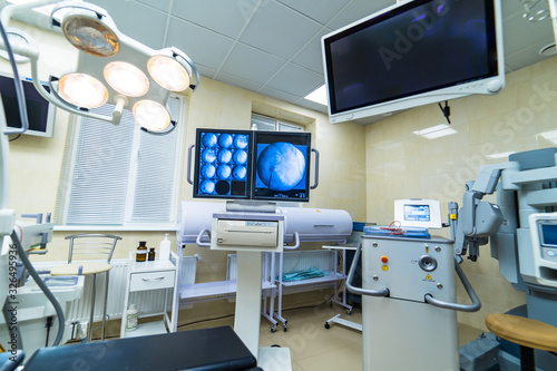 Clinic interior with operating surgery table, lamps and ultra modern devices, technology, hi-tech interior, medicine concept