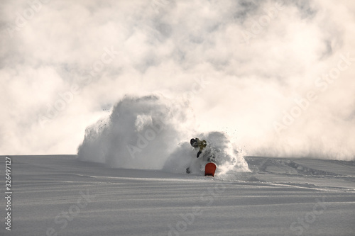 Male on a snowboard slides on a snowy mountain side photo