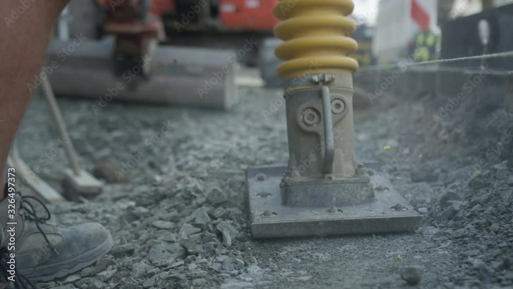 Worker on construction site with vibrating rammer