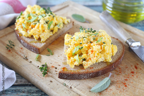 Scrambled eggs on slice of rye bread for breakfast