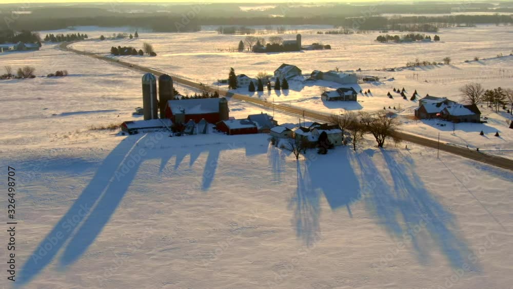 Silos cast long shadows across agricultural landscape, on winter snow, aerial view. Silos cast long shadows across agricultural landscape, on winter snow, aerial view.
