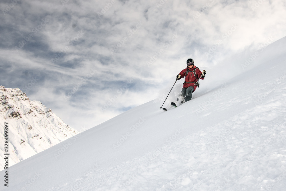 Smiling skiier slides down the mountain side