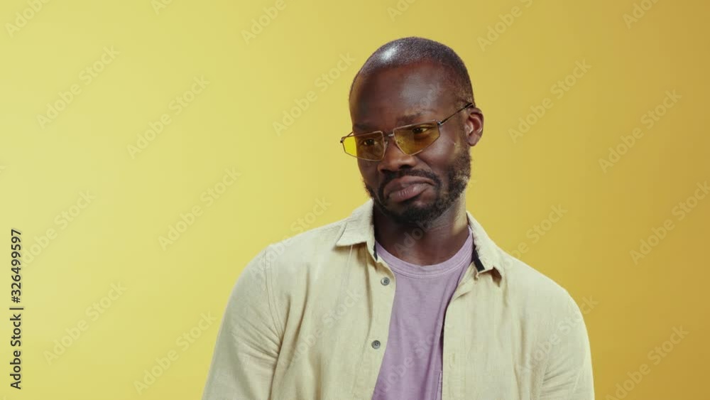 Portrait comical african stylish man looks for girls flirting with eyes lips watching people posing at yellow background. Studio shot. Human expressions. Fun concept. Portrait comical african stylish man looks for girls flirting with eyes lips watching people posing at yellow background. Studio shot. Human expressions. Fun concept.