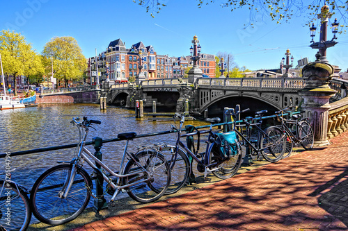 Photography Bicycles lining the canals of Amsterdam at the famous Blauwbrug bridge, Netherla