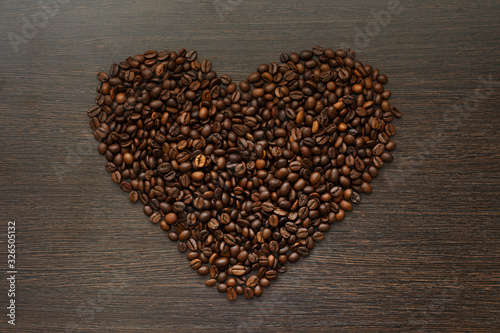 texture of coffee beans in heart shape on dark wooden surface