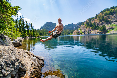 Male hiker jumping into an alpine lake in Washington State.