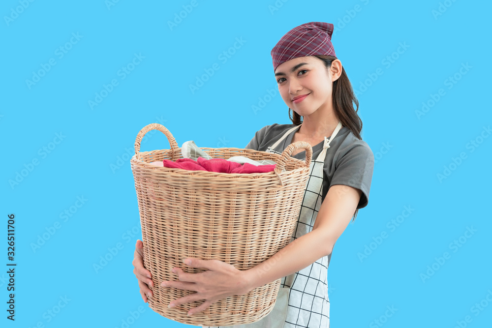 Young woman holding basket clothing laundry blue background Young woman holding basket clothing laundry blue background