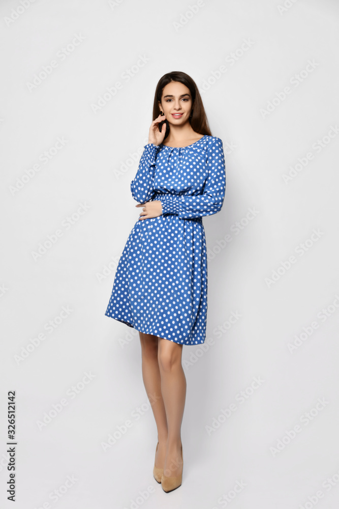 Young beautiful woman posing in new casual fashion spring light blue polka dot dress full body Young beautiful woman posing in new casual fashion spring light blue polka dot dress full body