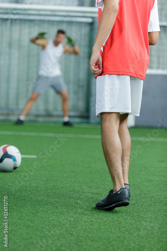 rear view of young men playing football indoors