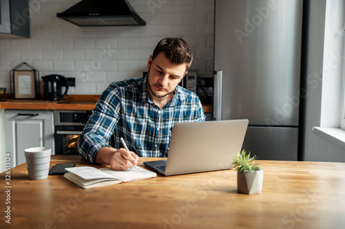 Young male freelancer works from home photo