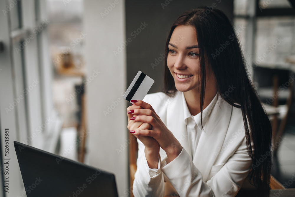 girl office worker holding a credit card in her hands