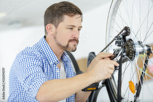 man fixing wheel of bike