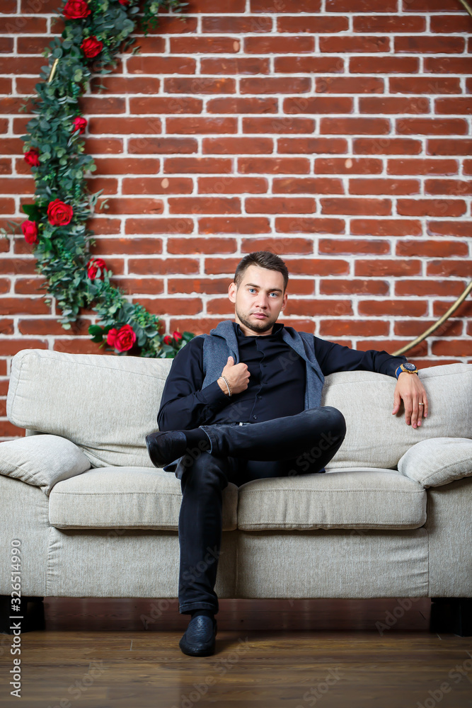 young guy businessman in a shirt on a sofa