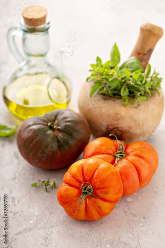 Ripe and fresh heirloom tomatoes with olive oil and herbs