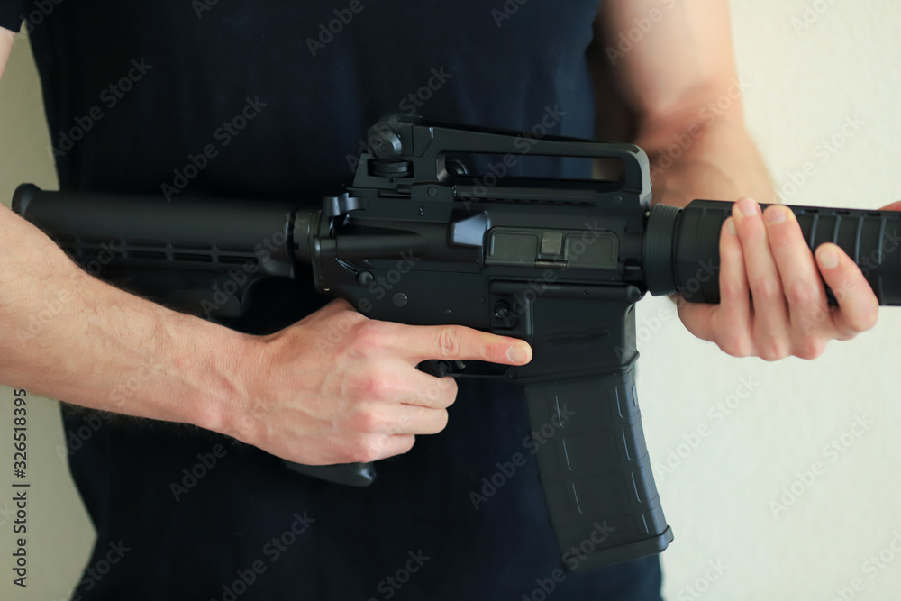 Man holding an Ar15 assault rifle wearing black shirt Stock Photo