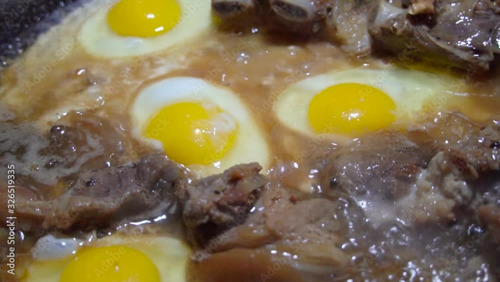 eggs and pork are fried in a pan in fat. The concept of poor and not healthy eating. Slow motion. eggs and pork are fried in a pan in fat. The concept of poor and not healthy eating. Slow motion.