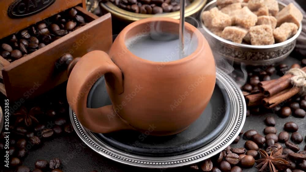 Stir coffee in a cup with a spoon. Stir coffee in a cup with a spoon.