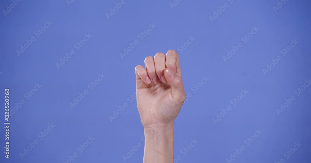 Woman showing S letter on blue background, closeup. Sign language Woman showing S letter on blue background, closeup. Sign language