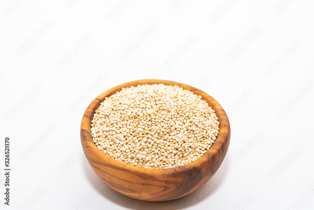 Raw quinoa in a wooden bowl isolated on white background with copy space Raw quinoa in a wooden bowl isolated on white background with copy space