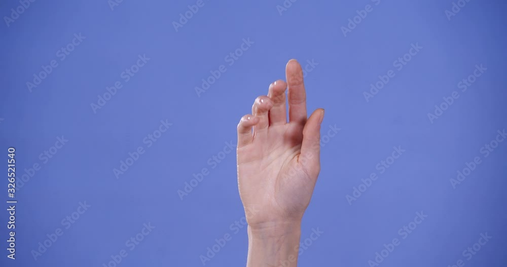 Woman showing T letter on blue background, closeup. Sign language Woman showing T letter on blue background, closeup. Sign language