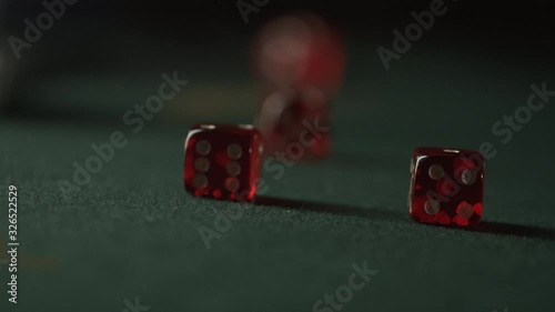 Red Dices rolling towards camera on green. Slow Motion