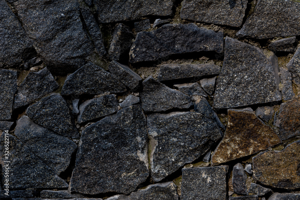 fence of black stones of irregular shape fence of black stones of irregular shape