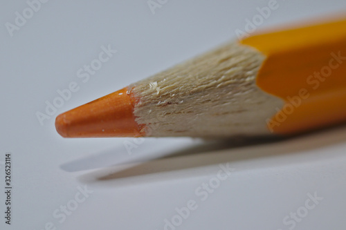 Orange pencil sitting on white desk