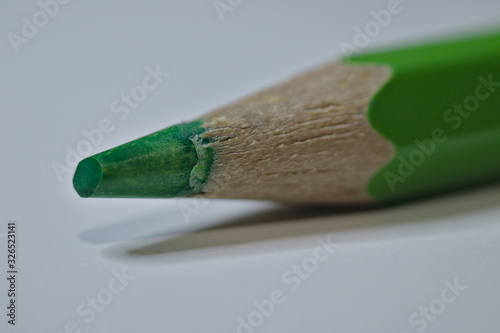 Green pencil sitting on white desk