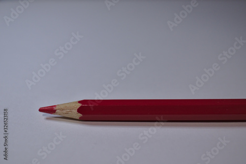 Red pencil sitting on white desk