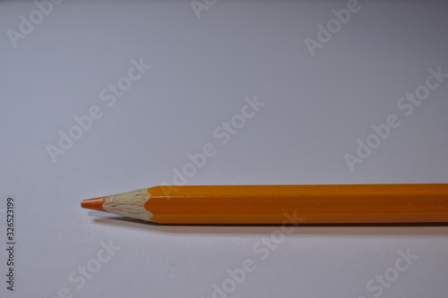 Orange pencil sitting on white desk