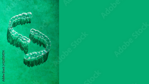 Invisible aligners teeth brackets on green background
