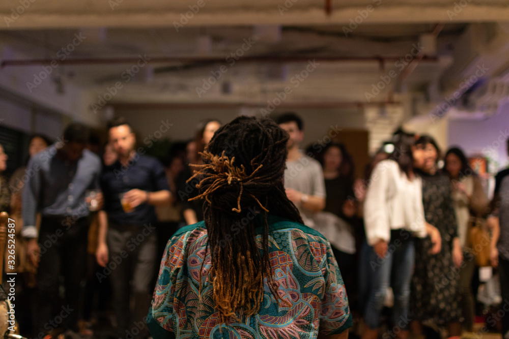 Obraz premium African black man with dreadlocks in front of a group of people from different cultures. Artist in front of the public.