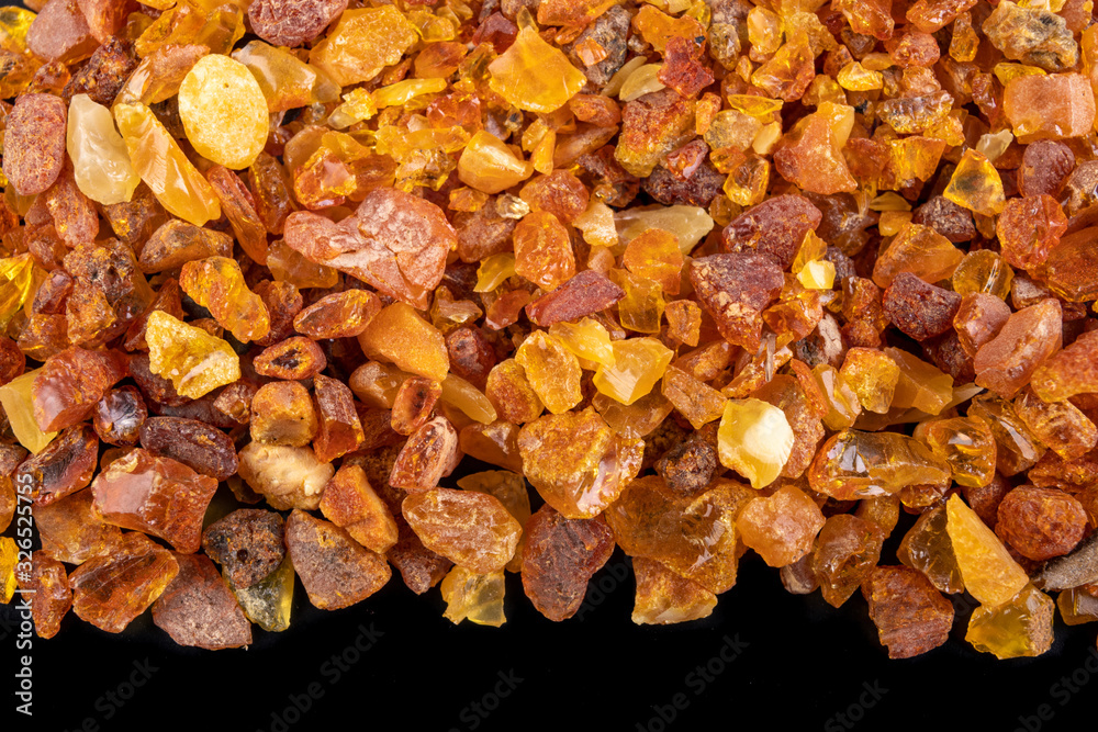 Small amber stones on a dark table. A pile of small ambers found on the Baltic beach. Small amber stones on a dark table. A pile of small ambers found on the Baltic beach.